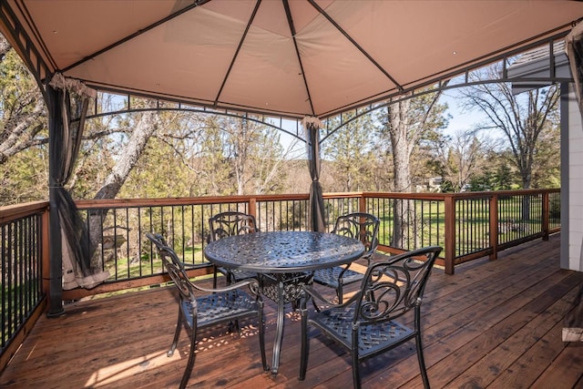 wooden terrace with a gazebo and outdoor dining area