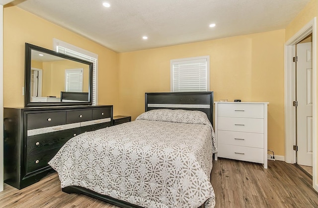 bedroom with recessed lighting, baseboards, and wood finished floors