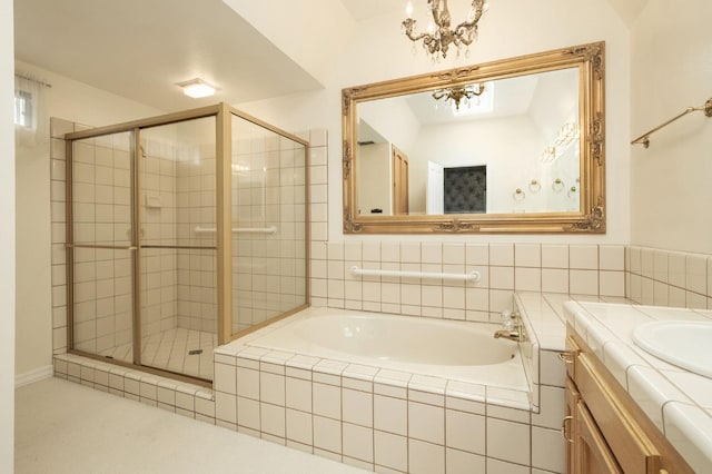 bathroom with a bath, a chandelier, a shower stall, and vanity