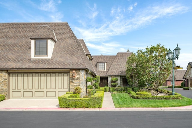 view of front of house with stone siding, concrete driveway, and a shingled roof