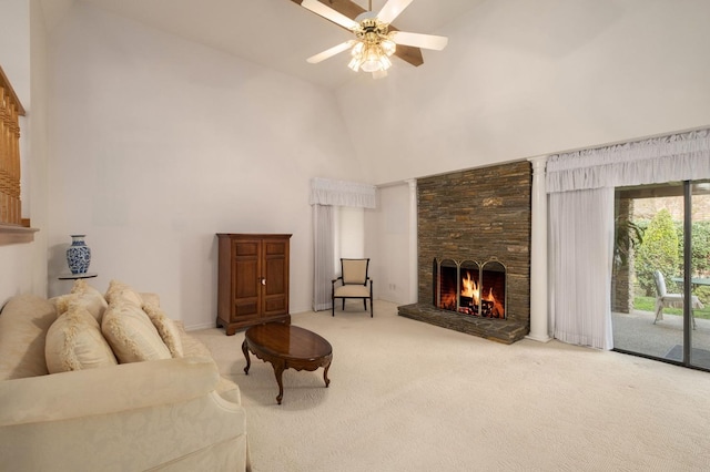 carpeted living area with a stone fireplace, ceiling fan, and high vaulted ceiling