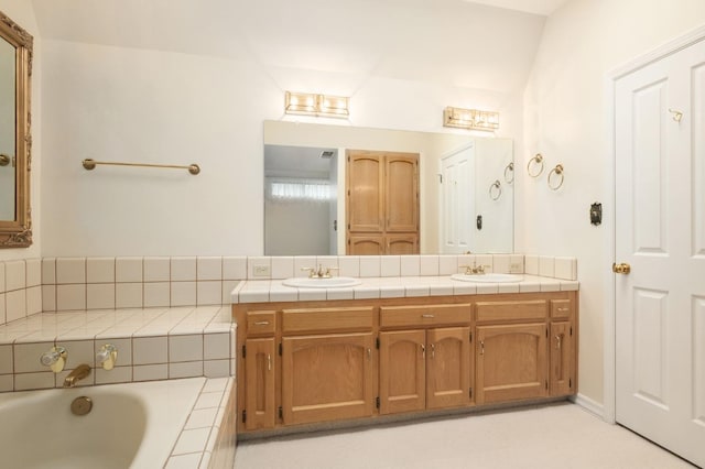 full bath with a sink, a bath, and double vanity