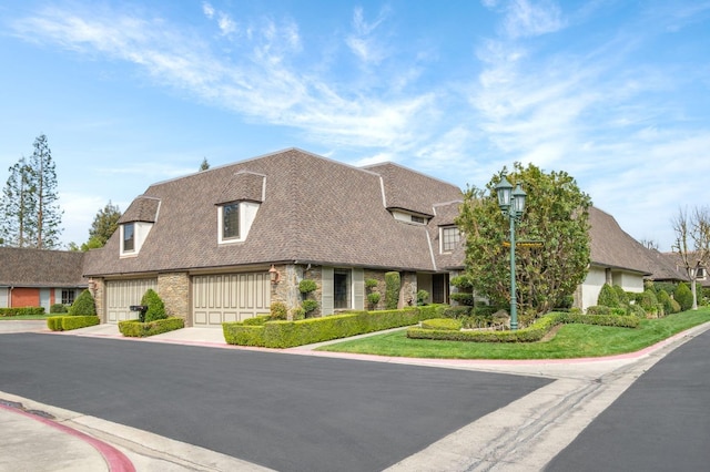 view of front of property with brick siding, driveway, and a shingled roof