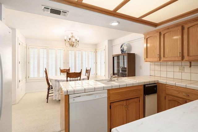 kitchen featuring visible vents, dishwasher, a peninsula, and a healthy amount of sunlight