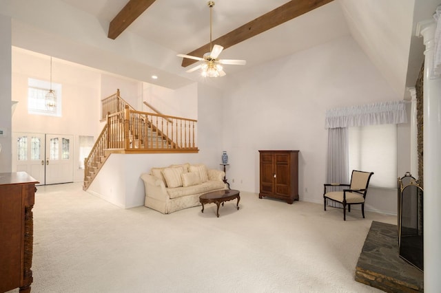 sitting room featuring carpet flooring, high vaulted ceiling, beamed ceiling, and stairs