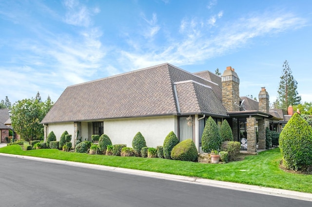 view of home's exterior featuring stucco siding, a lawn, roof with shingles, and a chimney