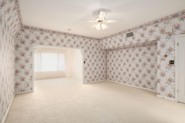 empty room featuring visible vents, wallpapered walls, and carpet