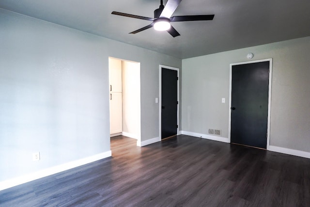 spare room with visible vents, baseboards, a ceiling fan, and dark wood-style flooring