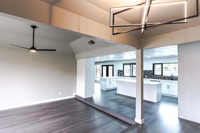 interior space with dark wood-style floors, visible vents, a ceiling fan, and baseboards