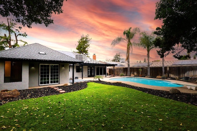 view of pool featuring a lawn, a patio, a fenced backyard, a diving board, and a fenced in pool