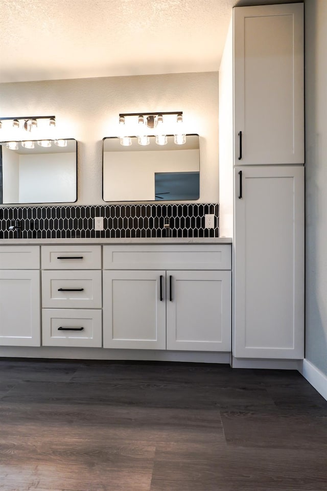 bathroom featuring double vanity, a textured ceiling, and wood finished floors