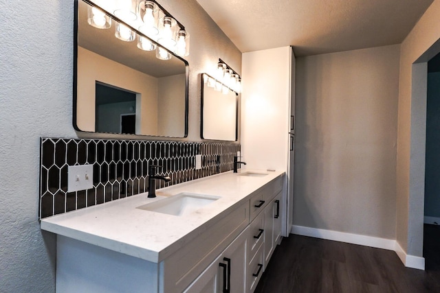 full bathroom featuring wood finished floors, baseboards, backsplash, and a sink