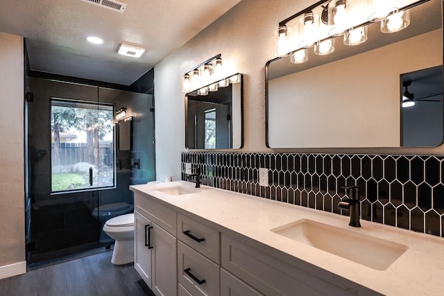 full bath featuring a shower stall, toilet, wood finished floors, and a sink