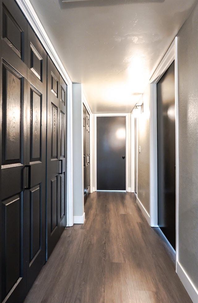 hall featuring baseboards and dark wood-style floors