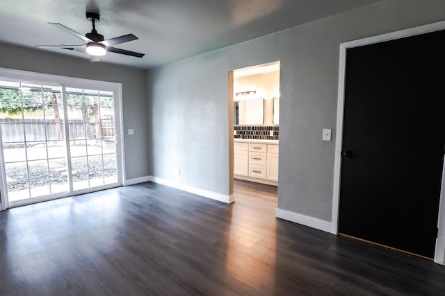 interior space featuring a ceiling fan, dark wood-style floors, and baseboards