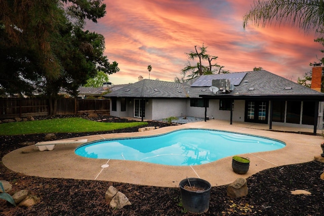 pool at dusk with a fenced in pool, a patio, a fenced backyard, and french doors