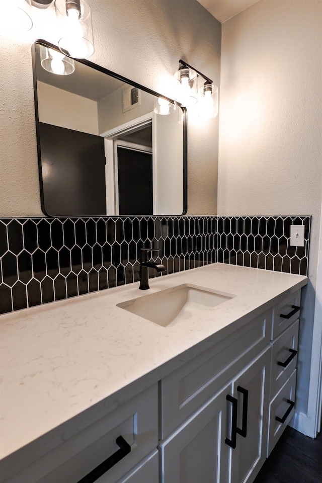 bathroom featuring visible vents, tasteful backsplash, and vanity