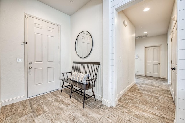 entryway with recessed lighting, visible vents, baseboards, and wood finished floors