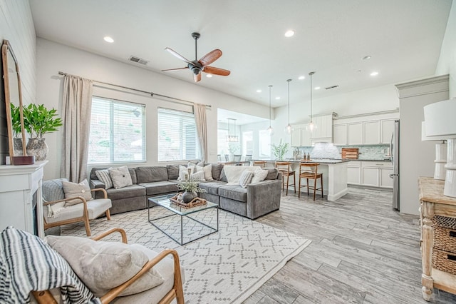 living room featuring ceiling fan, visible vents, light wood-style flooring, and recessed lighting