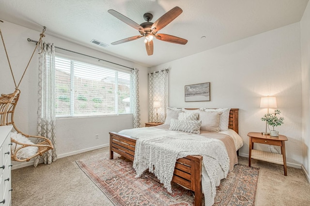 bedroom with visible vents, baseboards, light carpet, a textured ceiling, and a ceiling fan