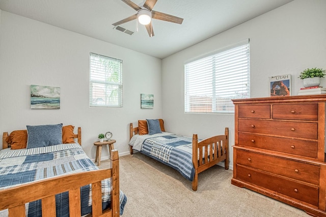 bedroom with visible vents, multiple windows, and light colored carpet