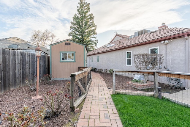 exterior space with a storage unit, central AC, an outdoor structure, and fence