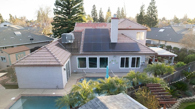 back of property featuring a patio area, central air condition unit, a tiled roof, and a chimney