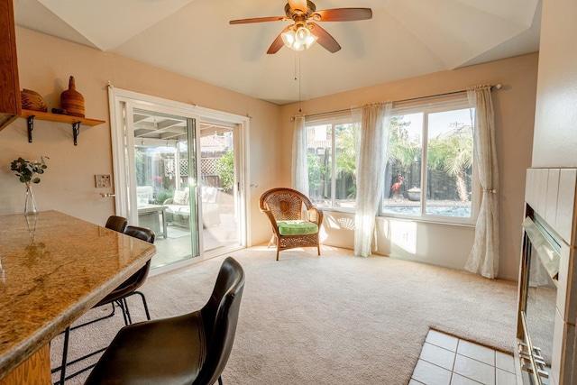 interior space with lofted ceiling, a fireplace, and a ceiling fan