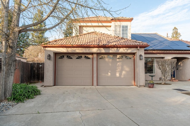 view of front of property with a tile roof, driveway, roof mounted solar panels, and stucco siding