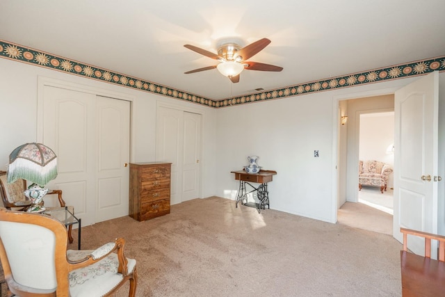 sitting room featuring ceiling fan and carpet floors