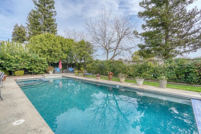 view of pool with a patio area, a fenced backyard, and a pool with connected hot tub