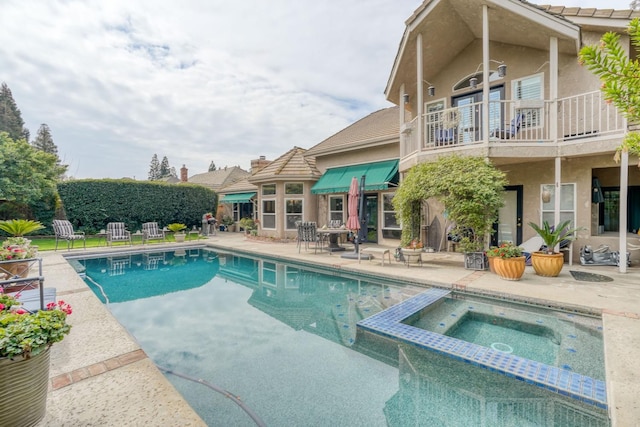 view of pool with a patio and a pool with connected hot tub