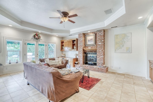 851 E Country View Cir, Fresno, CA 93730 - living area with a tray ceiling, ceiling fan, crown molding, a brick fireplace, and light tile patterned flooring