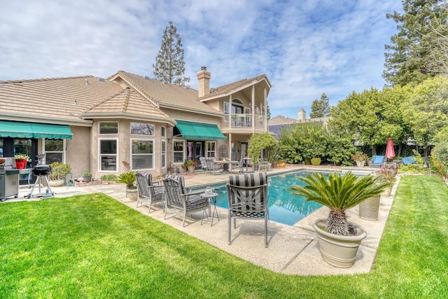 pool featuring a patio and a lawn