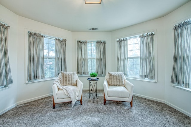 living area featuring a healthy amount of sunlight, visible vents, and baseboards