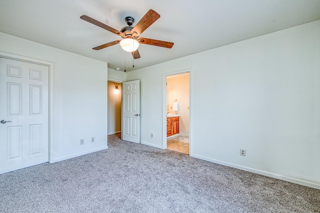 unfurnished bedroom with light carpet, ensuite bath, baseboards, and a ceiling fan