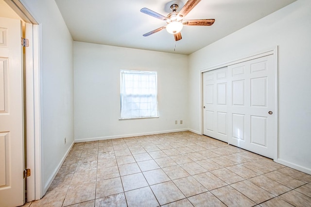 unfurnished bedroom with light tile patterned floors, a ceiling fan, baseboards, and a closet