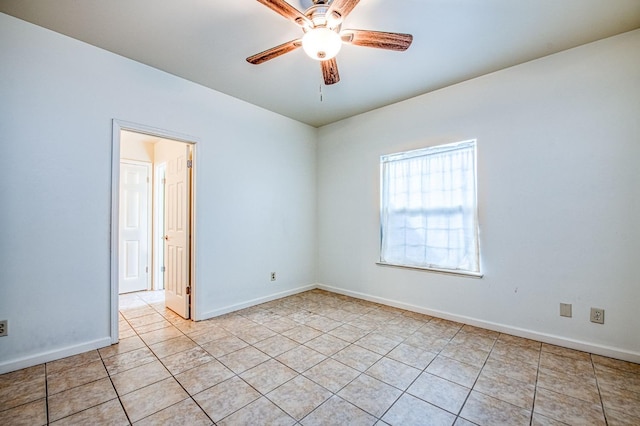 empty room featuring light tile patterned floors, baseboards, and ceiling fan