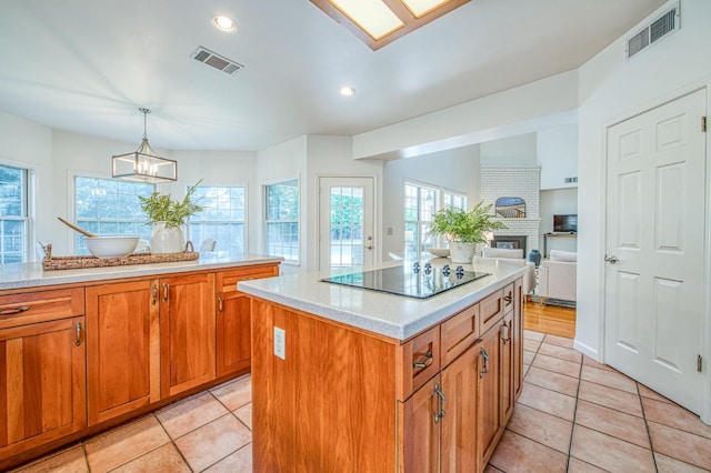 kitchen with brown cabinetry, visible vents, light countertops, and black electric cooktop