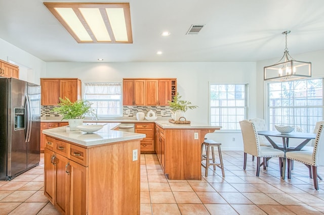 kitchen with tasteful backsplash, a kitchen bar, light countertops, a peninsula, and stainless steel appliances