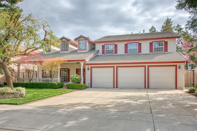 view of front of house with a tile roof, concrete driveway, and fence