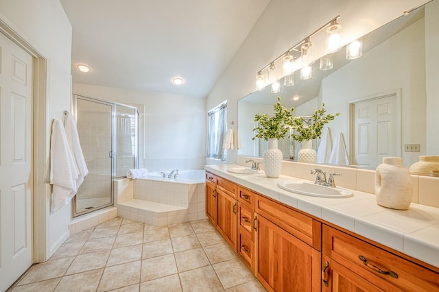 full bath with a bath, vaulted ceiling, tile patterned flooring, and a sink