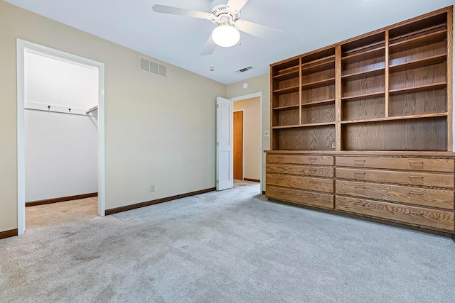 unfurnished bedroom with a spacious closet, baseboards, visible vents, and carpet floors