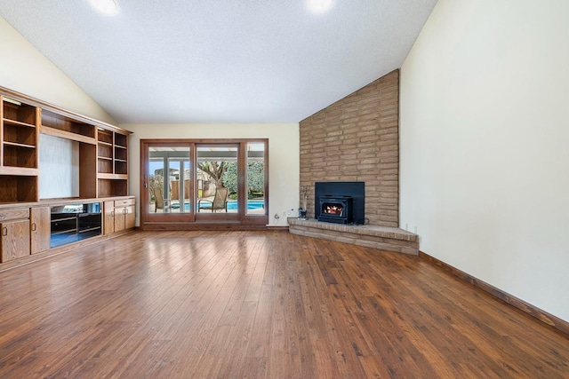 unfurnished living room with hardwood / wood-style floors, a brick fireplace, baseboards, and high vaulted ceiling