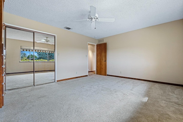 unfurnished bedroom with baseboards, visible vents, a closet, a textured ceiling, and carpet flooring