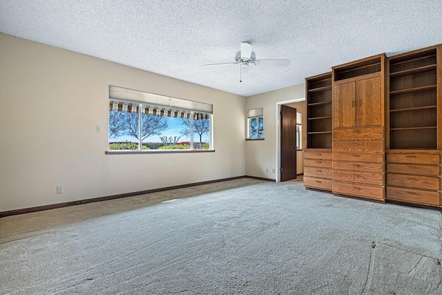 interior space featuring a textured ceiling, baseboards, and a ceiling fan