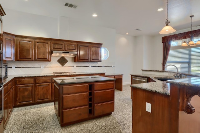 kitchen featuring a center island with sink, visible vents, stainless steel appliances, a sink, and under cabinet range hood