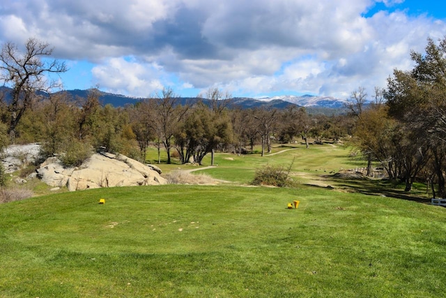 surrounding community with a mountain view and a yard