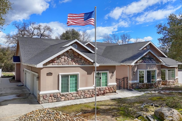 craftsman house featuring a garage, stone siding, roof with shingles, and stucco siding