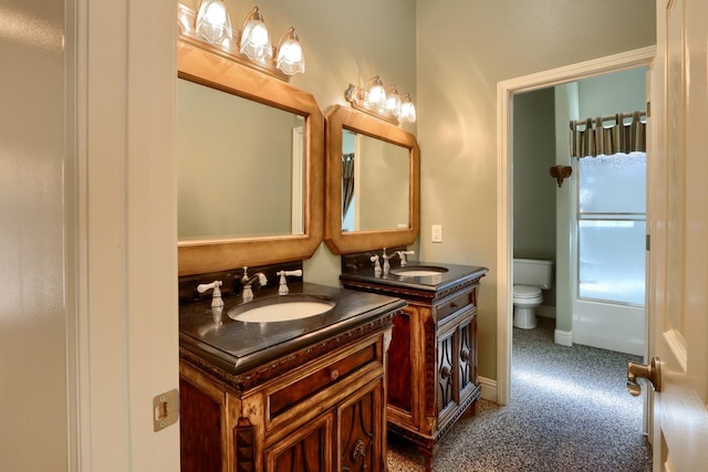 bathroom featuring toilet, vanity, and baseboards